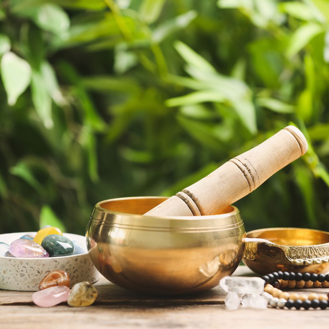 bronze singing bowl with green leaves as background