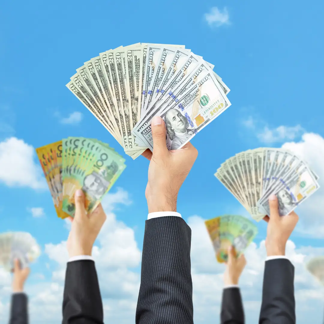 hands raised to the sky holding hundred dollar bills representing business growth