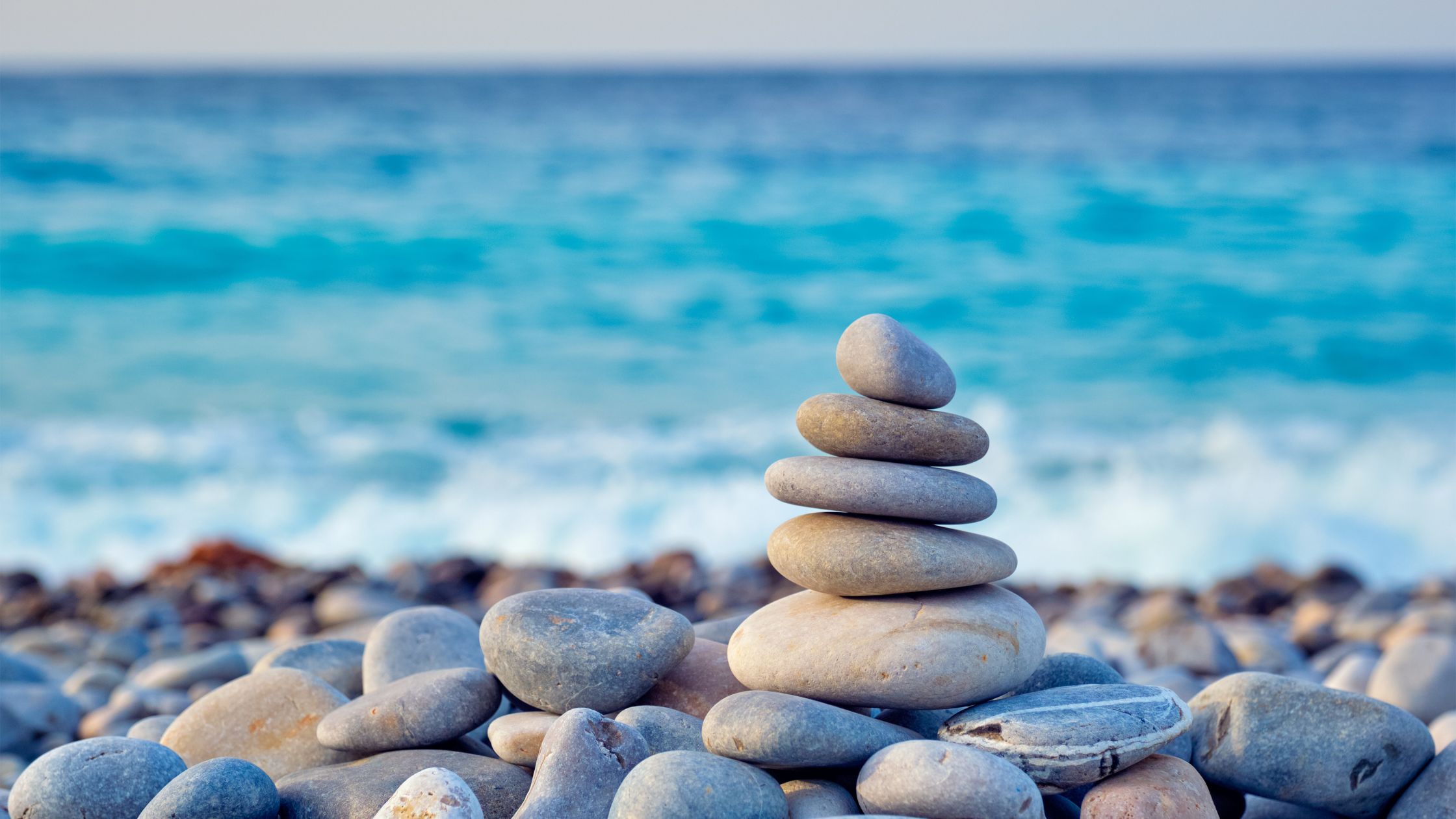 stacked rocks on a beach used as a generic graphics for reiki, salt, and sound event.