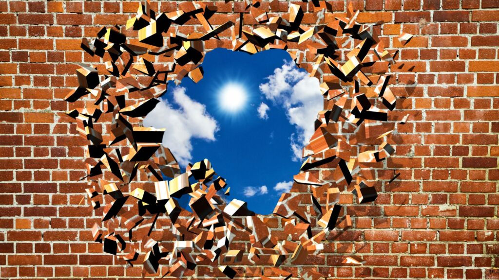 broken brick wall with a circle that lets in a view of the sky