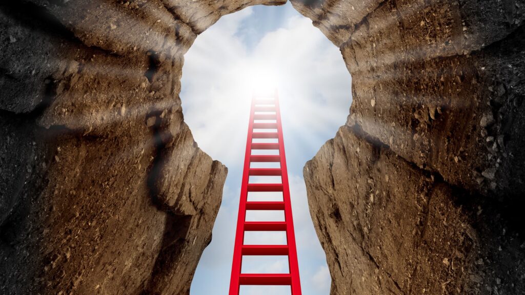 red ladder in a keyhole shaped opening of a hole. it is reaching towards the sun in the sky