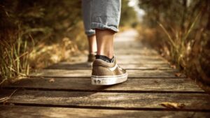 taking the lead by walking your own path, pictured by feet on a wooden surface