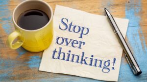 coffee mug with notepad reading "stop overthinking"